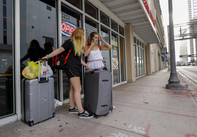 Dos turistas británicas esperan con sus maletas para poder salir de Miami ante la inminente llegada del huracán Irma, en Miami, Florida, hoy 8 de septiembre de 2017. EFE