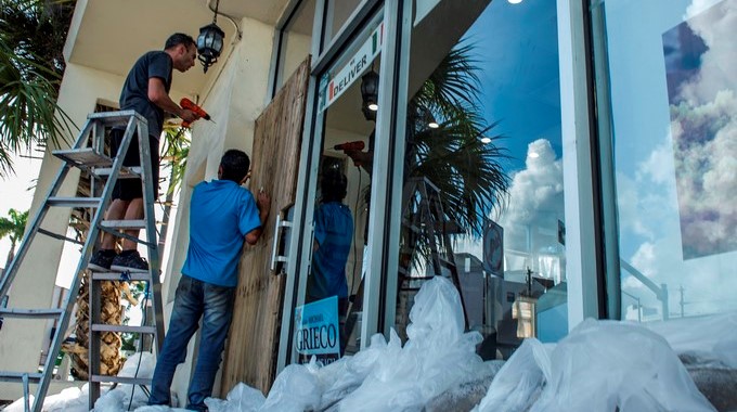 Dos hombres aseguran las puertas y ventanas de un ubicado en Miami (Estados Unidos). EFE