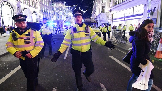Varios policías dan indicaciones a los transeúntes mientras vigilan en una zona próxima a la estación de metro de Oxford Circus, en el centro de Londres (Reino Unido) hoy, 24 de noviembre de 2017. EFE