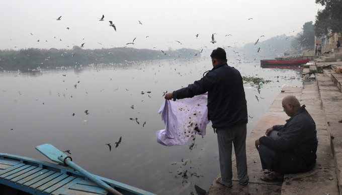 Un niño arroja basura al río Yamuna, en Nueva Delhi (India). EFE