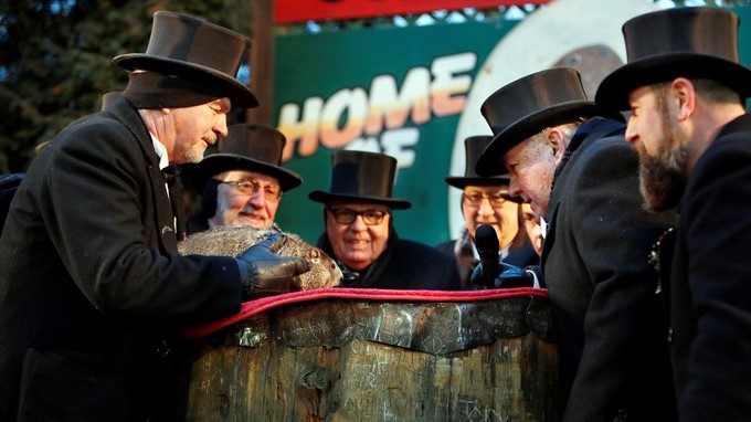El cuidador John Grifiths (i), del Club de la Marmota, sostiene a la marmota Phil mientras el vicepresidente del club, Jeff Lundy (2d), lee la predicción de Phil para este año en Punxsutawney, Pensilvania, Estados Unidos hoy, 2 de febrero de 2018. EFE