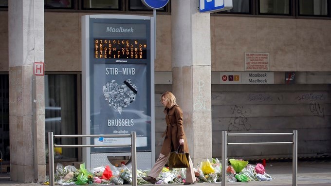 Una mujer camina junto a la entrada de la estación de metro de Maalbeek en Bruselas, decorada con ramos de flores, unos días después del doble atentado en el que al menos 35 personas murieron y más de 300 resultaron heridas. EFEArchivo