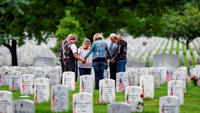 Una familia reza alrededor de una tumba durante la celebración del Día de los Caídos en el Cementerio Nacional de Arlington National Cemetery en Arlington (EE.UU.). EFE