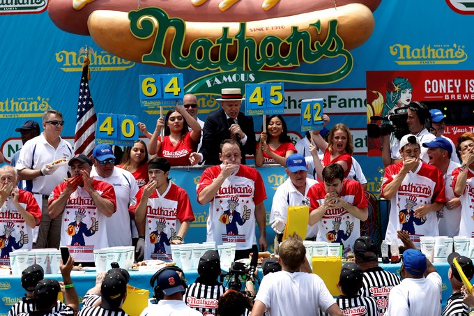 Varias personas participan en un concurso de comer perritos calientes en Nueva