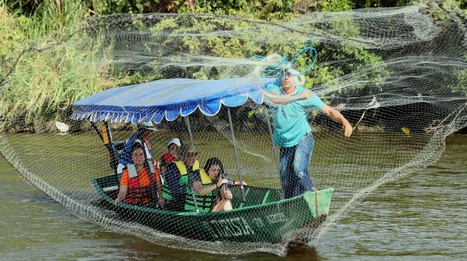 Fotografía tomada el pasado 25 de septiembre en la que se registró a un grupo de turistas, durante un recorrido con pescadores por el río Magdalena, en el municipio de Villavieja (departamento de Huila, Colombia). EFE