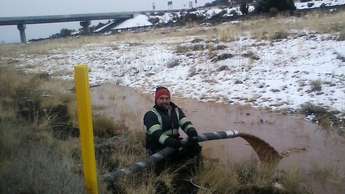 Hombre posa junto a un río de chocolate, luego de que un camión cisterna vertiera su dulce contenido en una carretera de la ciudad de Flagstaff (Arizona, EE.UU.). EFE