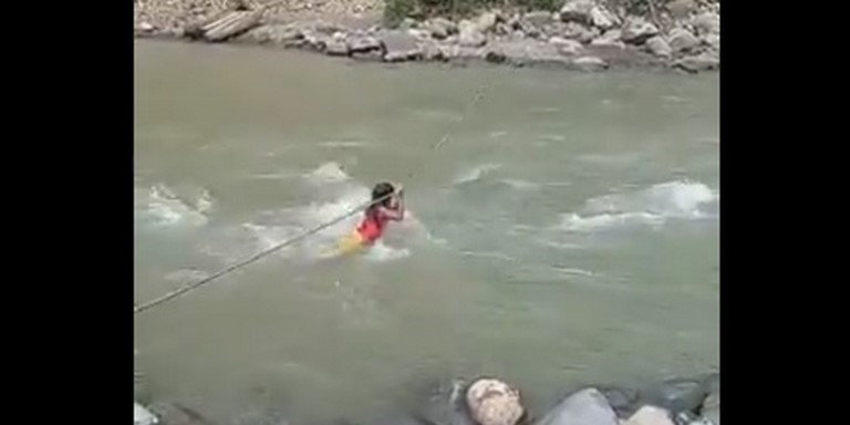Niños pasando colgados de puente