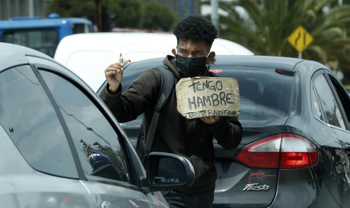 Pobreza en Colombia subió al 42,5 % en 2020, impulsada por la pandemia 1 Un hombre vende dulces y pide ayuda en un semáforo en Bogotá (Colombia). EFE/ Mauricio Duenas Castañeda/Archivo