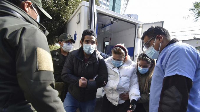La expresidenta de Bolivia, Jeanine Áñez, camina hoy acompañada por sus hijos José Armando Ribera (i) y Carolina Ribera (d) hacia un centro médico para realizarse unos exámenes, en La Paz (Bolivia). EFE/Stringer Jeanine Áñez