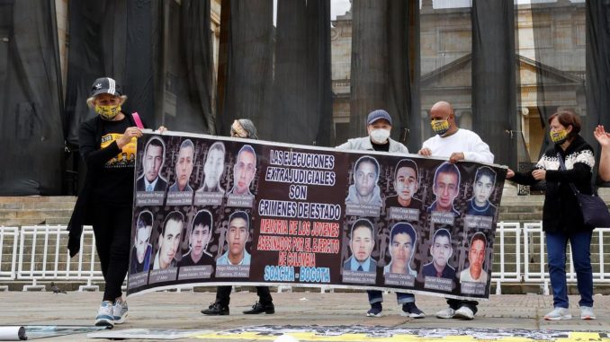 Manifestantes levantan un cartel hoy durante una presentación para reivindicar personas desaparecidas, en la plaza de Bolívar en Bogotá (Colombia). Estudiantes universitarios realizan en el Día Internacional de los Desaparecidos una presentación reivindicativa por las 6.402 ejecuciones de jóvenes por el Ejército de Colombia en uno de los episodios más oscuros del conflicto conocido como "falsos positivos". EFE/ Mauricio Dueñas Castañeda desaparecidos en Colombia