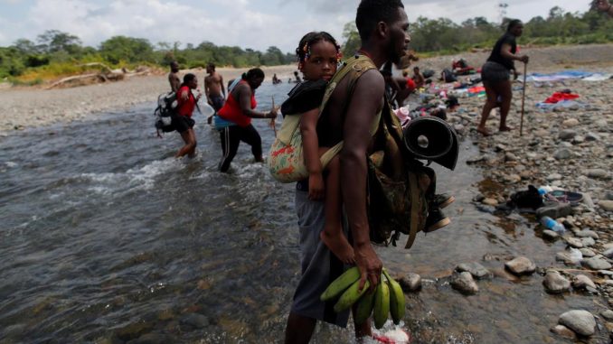 Migrantes caminan a través del río turquesa hacía la comunidad de Bajo Chiquito, tras caminar desde Colombia atravesando la selva del Darién (Panamá). EFE/ Bienvenido Velasco/Archivo Migrantes