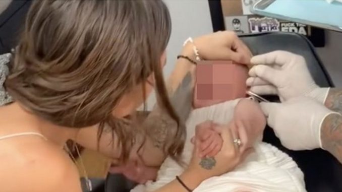 mujer perforación de las orejas bebé
