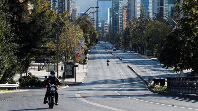 Un motociclista transita por una avenida casi vacía en Santiago (Chile). EFE/Alberto Valdés/Archivo Semana