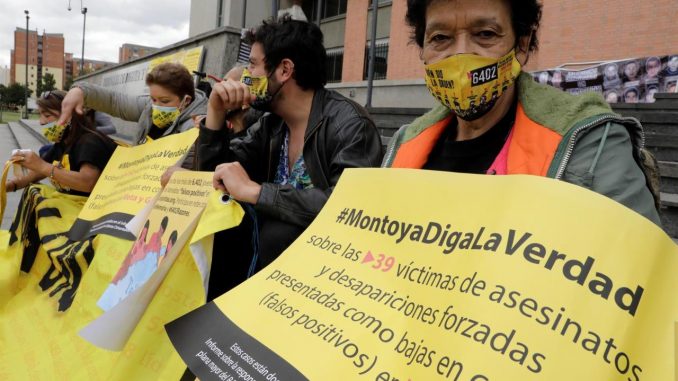 Una mujer muestra un cartel de protesta directa contra el general retirado del Ejército de Colombia Mario Montoya sobre los llamados "falsos positivos", durante un plantón de colectivos de familiares de víctimas de dichas ejecuciones extrajudiciales, hoy, frente a la sede de los Tribunales de Bogotá y Cundinamarca, en Bogotá (Colombia). EFE/ Carlos Ortega Mario Montoya
