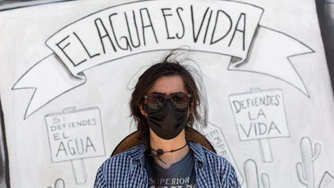 Fotografía cedida por Global Witnes con fecha del 26 de julio de 2021 del activista Jesus Francisco Galaz, vocero de Mexicali Resiste, se para al frente de una pancarta con el lema "El agua es vida". EFE/ Felipe Luna/Global Witness líderes ambientales