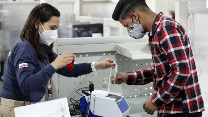 Ciudadanos venezolanos acuden ante trabajadores de migración Colombia para realizar su registro biométrico, consistente en la toma de huellas, fotografía de rostro y firma, hoy, en Bogotá (Colombia). EFE/ Mauricio Dueñas Castañeda Registro biométrico