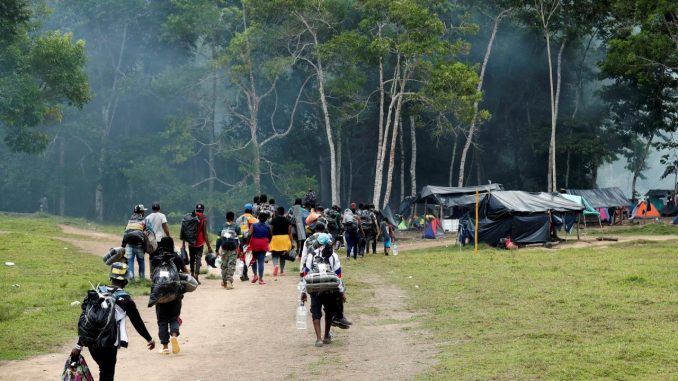 Migrantes haitianos cargan sus pertenencias para instalarse en un campamento donde pasarán la noche para iniciar su viaje hacia el Tapón del Darién, el 27 de septiembre de 2021, en Acandi (Colombia). EFE/ Mauricio Dueñas Castañeda éxodo