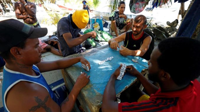 Migrantes haitianos y venezolanos juegan dominó hoy, en Necoclí (Colombia). EFE/ Mauricio Dueñas Castañeda Darién