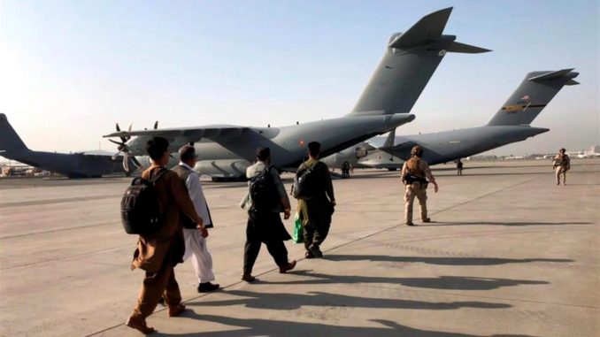 Varia personas esperaban su turno para abordar un avión militar en el aeropuerto internacional Hamid en Kabul, Afganistán, el pasado 23 de agoto. EFE/Stringer talibanes