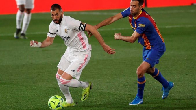 El delantero del Real Madrid Karim Benzema (i) se escapa de Sergio Busquets, del FC Barcelona, durante un partido. EFE/Juanjo Martín el clásico