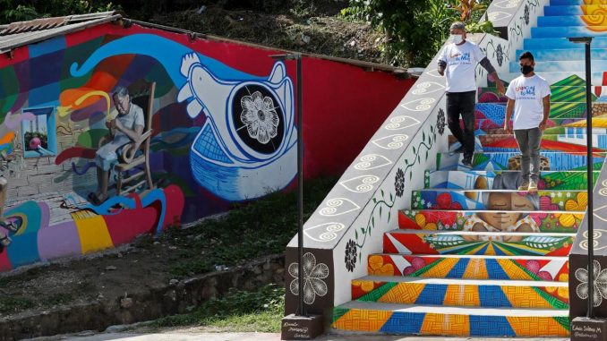 Fotografía fechada 15 de octubre de 2021 de los artistas Danilo Jiménez y Edwin Solano mientras caminan por las escaleras que pintaron en Usiacurí (Colombia). EFE/ Mauricio Dueñas Castañeda Usiacurí