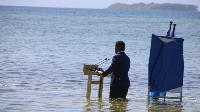 Ministro alerta el peligro del cambio climático con el agua a la cintura (2)