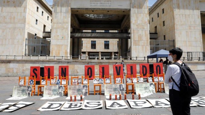 Familiares de las víctimas de desaparición forzada conmemoran con una exhibición de fotografías que conforman la Galería de la Memoria hoy domingo, 36 años de la toma del Palacio de Justicia, en la Plaza de Bolívar de Bogotá (Colombia). EFE/ Carlos Ortega Palacio de Justicia