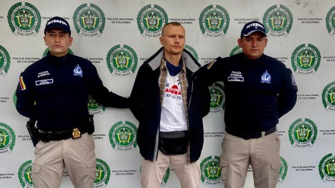 Fotografía cedida por la Policía Nacional de Colombia que muestra al ciudadano ruso Vladimir Taranetc, alias Ali Ali (c), mientras es acompañado por integrantes de la Interpol luego de ser capturado en Bogotá (Colombia). EFE/Policía Nacional de Colombia ruso