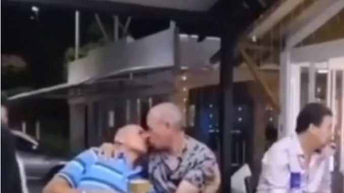 Luis Alberto Posada besando en la boca a un hombre