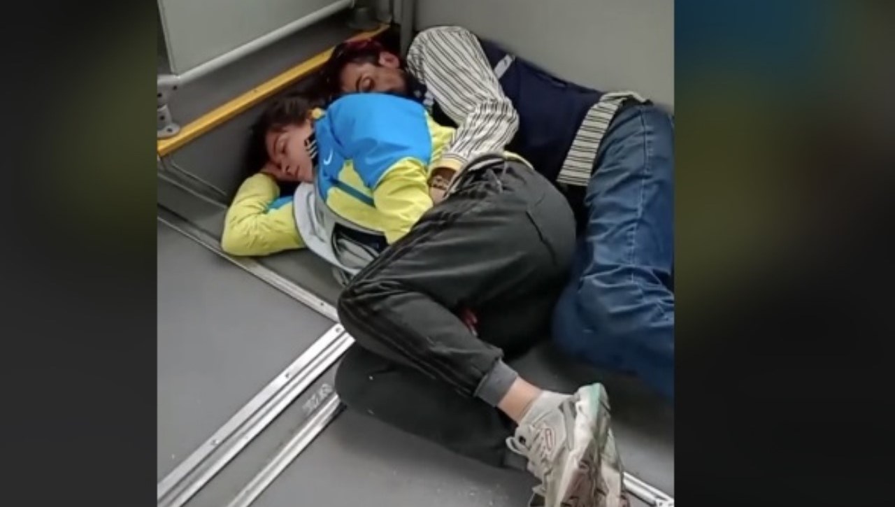 VIDEO. Abrazándose, pareja duerme en el piso de un TransMilenio