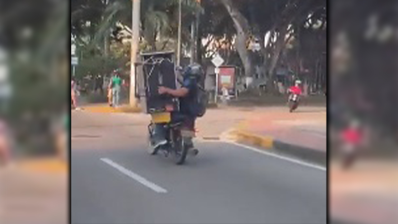 Dos hombres transportaron una estufa en un moto