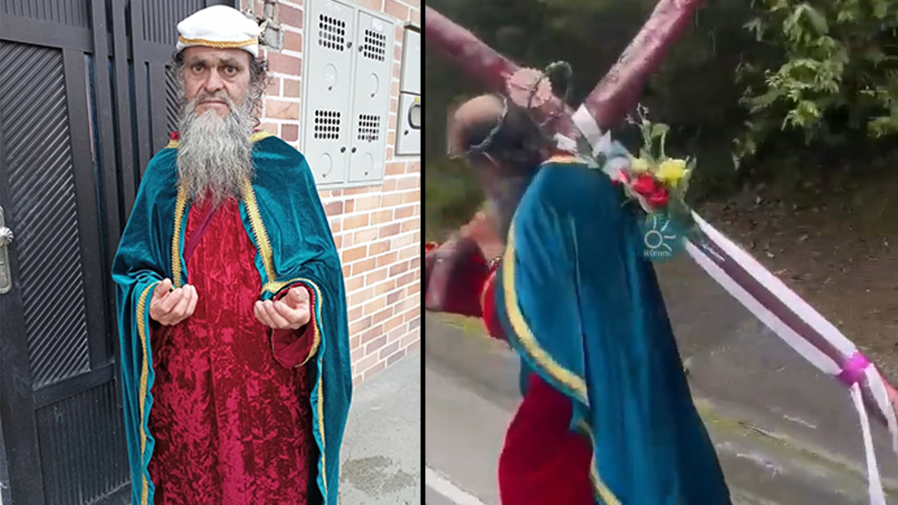 Un peregrino camina con una cruz encima por las vías antioqueñas