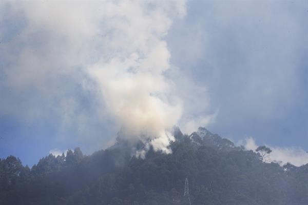 Los bomberos trabajan para extinguir un incendio en los cerros de Bogotá