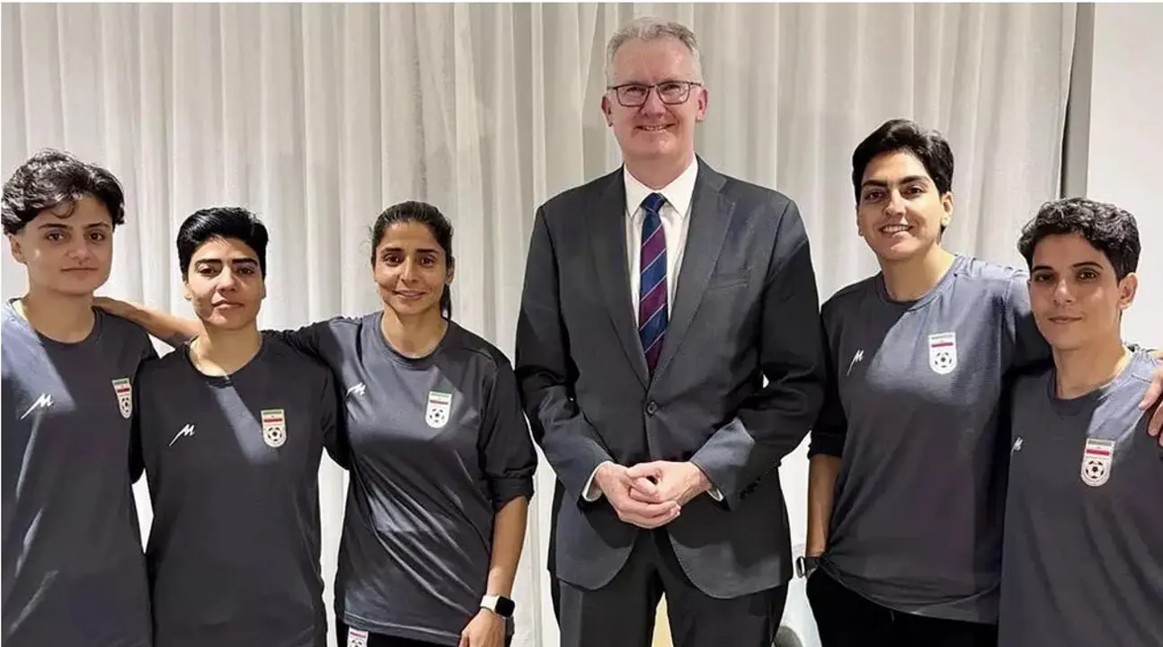 El ministro del Interior australiano Tony Burke junto a las cinco futbolistas iraníes que solicitaron asilo en Australia: Fatemeh Pasandideh, Mona Hamoudi y Atefeh Ramezanizadeh (a la izquierda del político) y Zahra Ghanbari y Zahra Sarbali (a su derecha). Fotografía del Ministerio del Interior de Australia