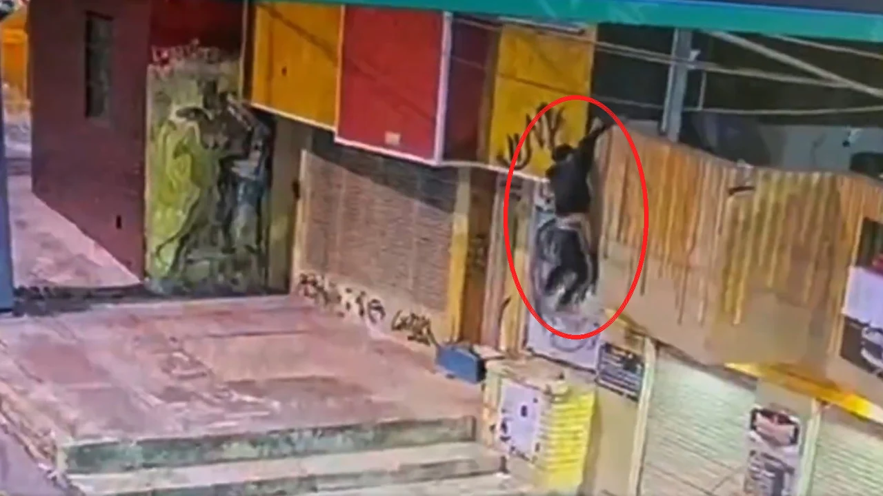 Hombre trepando un muro en La Candelaria, Bogotá, señalado con un círculo rojo