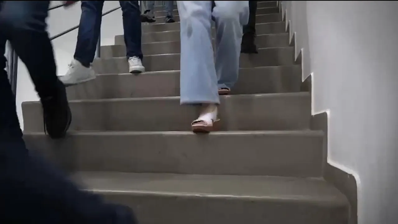 Personas bajan por una escalera durante un ejercicio de simulacro