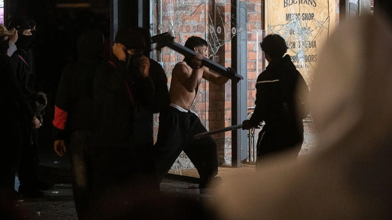Jóvenes destrozan el escaparate de un comercio durante los disturbios en Barcelona