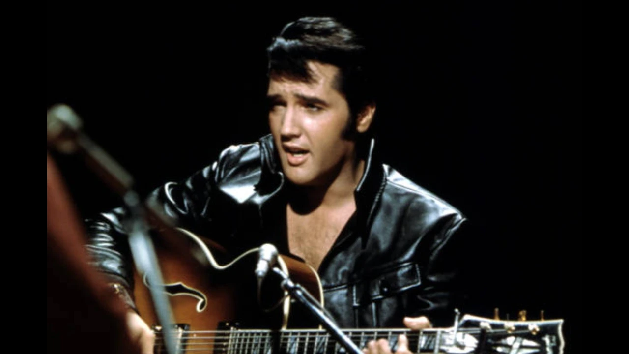 Elvis Presley durante una presentación con guitarra