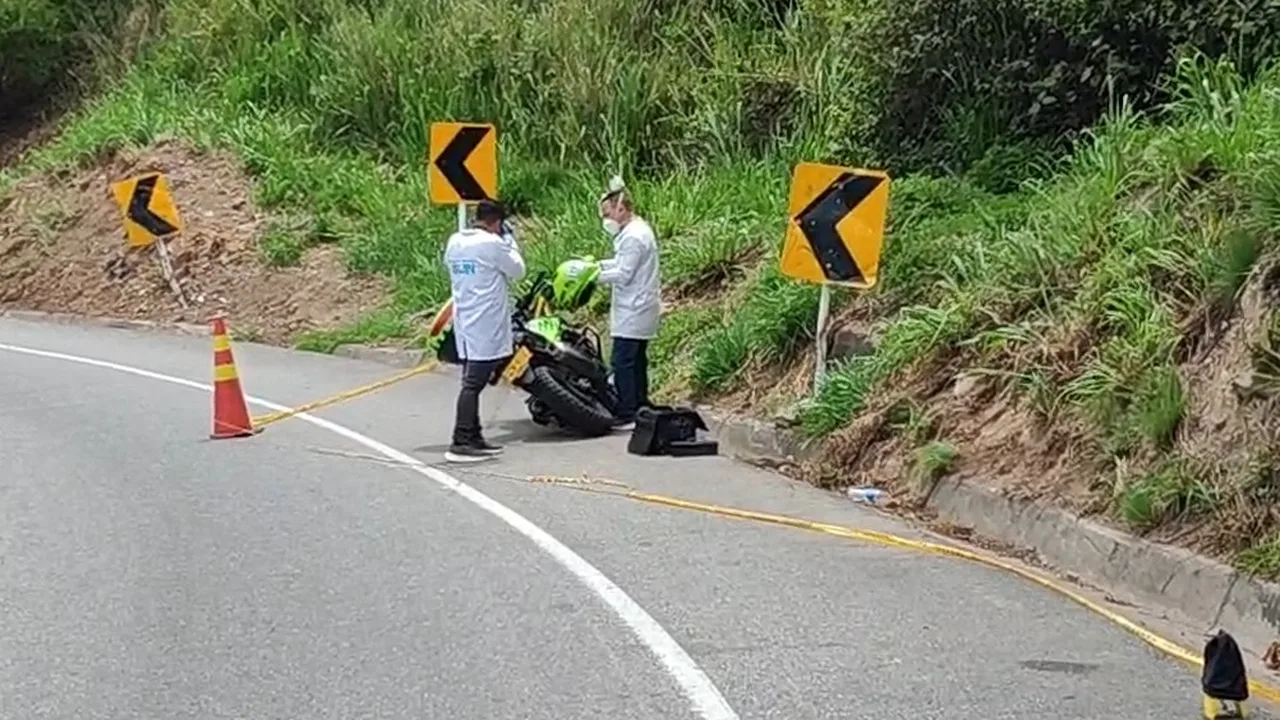 Investigadores revisan la motocicleta con distintivos de la Policía abandonada en la vía Girón-Lebrija