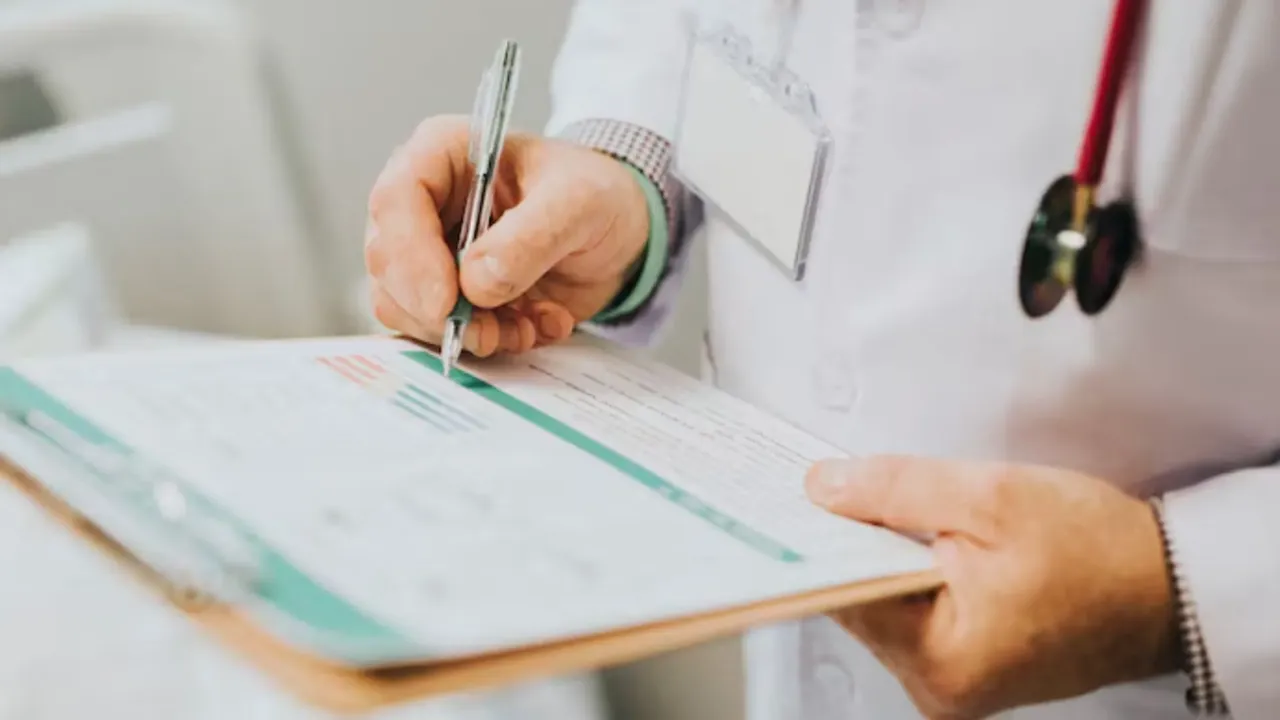 Mano de un médico escribiendo una receta