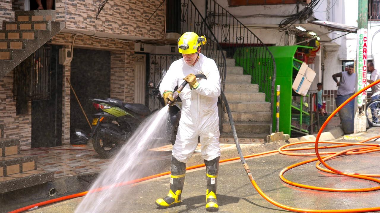 Alcaldía de Medellín ha entregado más de 800 ayudas a 330 familias afectadas por las lluvias 2 Operario lava con manguera una calle afectada por las lluvias en Medellín
