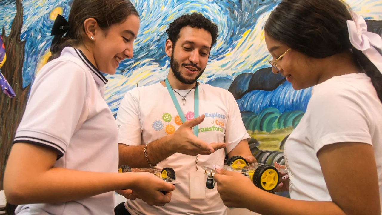 Robótica e IA en el aula: 125 estudiantes de Guayabal ganan habilidades digitales 1 Un docente explica a dos estudiantes de Guayabal cómo funcionan los carros robóticos que arman en los clubes de habilidades digitales