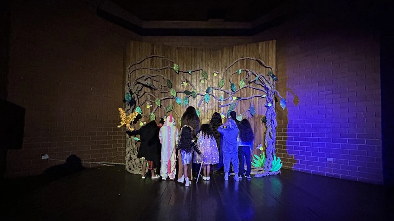 Bello se disfraza: conciertos, fogatas y misterio gratis hasta el 3 de noviembre 3 Niños con disfraces frente a un árbol decorado en un escenario en Bello