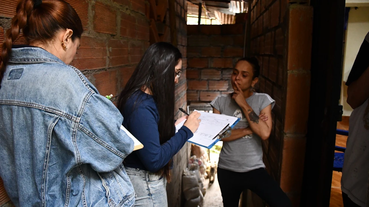 Noche de susto en Villas del Sol: la tierra cedió y dejó ocho casas afectadas en Bello 4 Funcionarios toman datos a una afectada por el movimiento en masa en Villas del Sol, Bello