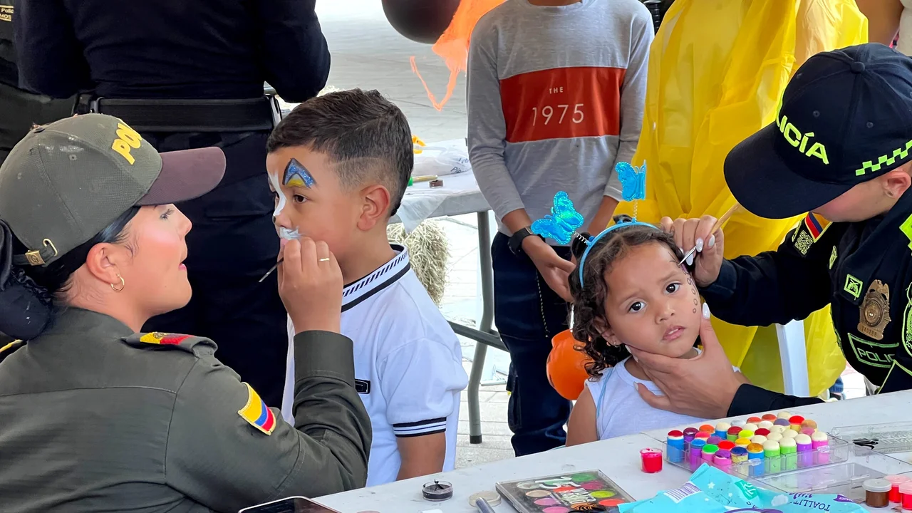 Día Dulce en Antioquia: la Policía sale con todo y deja recomendaciones clave para los papás 3 Uniformadas de la Policía pintan las caras de dos niños en la actividad por Halloween